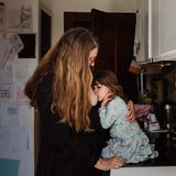 Eine Mutter steht mit ihrem Kind in der Küche und stillt