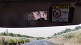 Im Rückspiegel eines Autos sieht man das Kind der Fotografin, das gerade gestillt wird