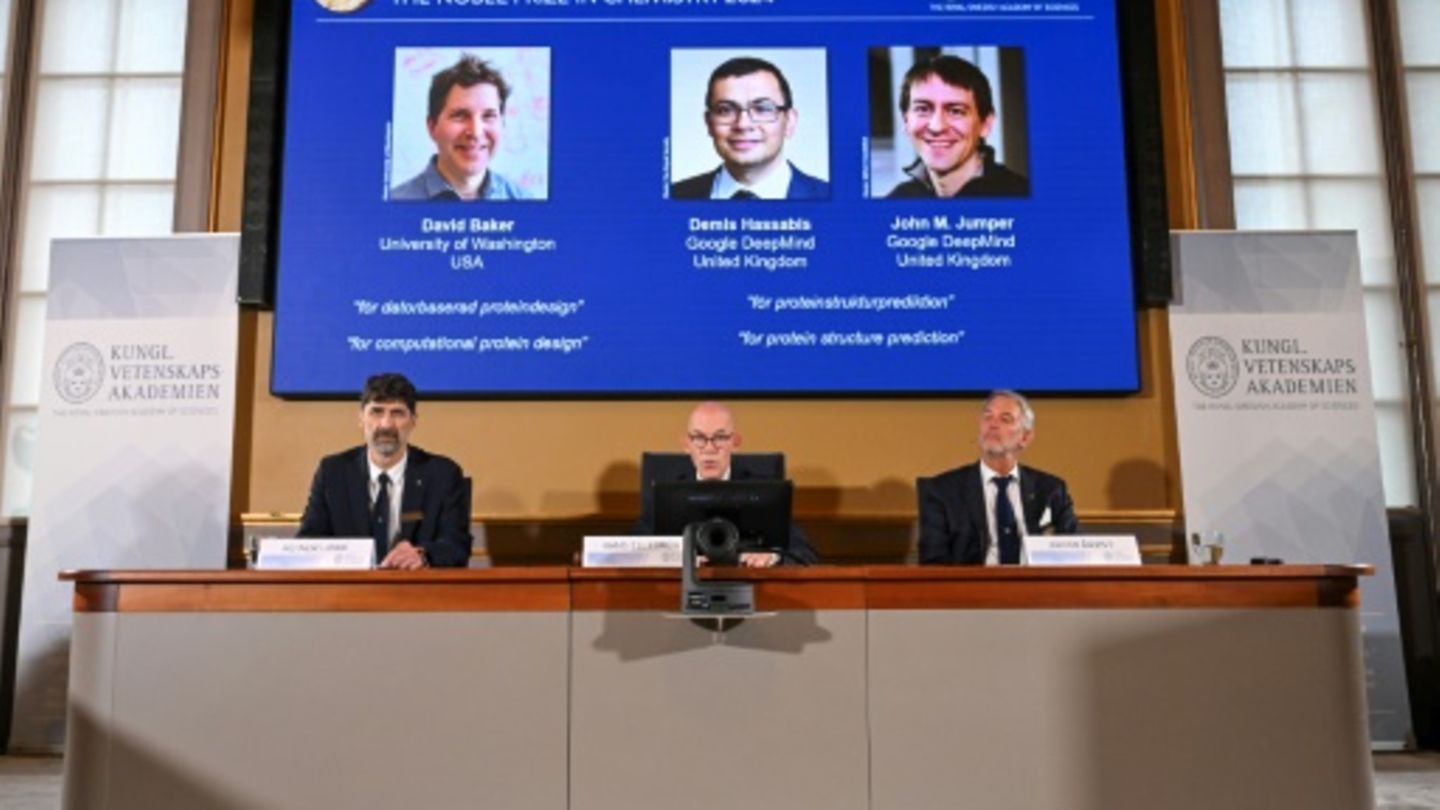 Nobel-Komitee vor Bildern der Preisträger
