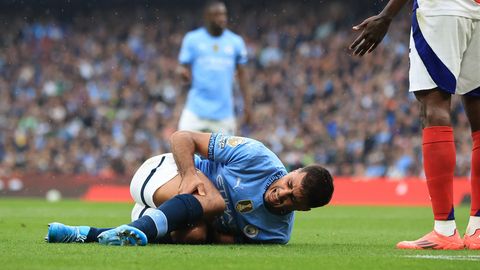 Manchester-City-Fußballer Rodri liegt auf dem Rasen und hält sich mit schmerzverzerrtem Gesicht das rechte Knie