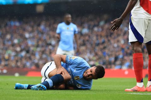 Manchester-City-Fußballer Rodri liegt auf dem Rasen und hält sich mit schmerzverzerrtem Gesicht das rechte Knie