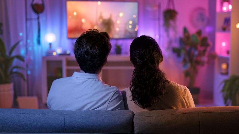 Samsung Q60D: Paar sitzt vor dem Fernseher.