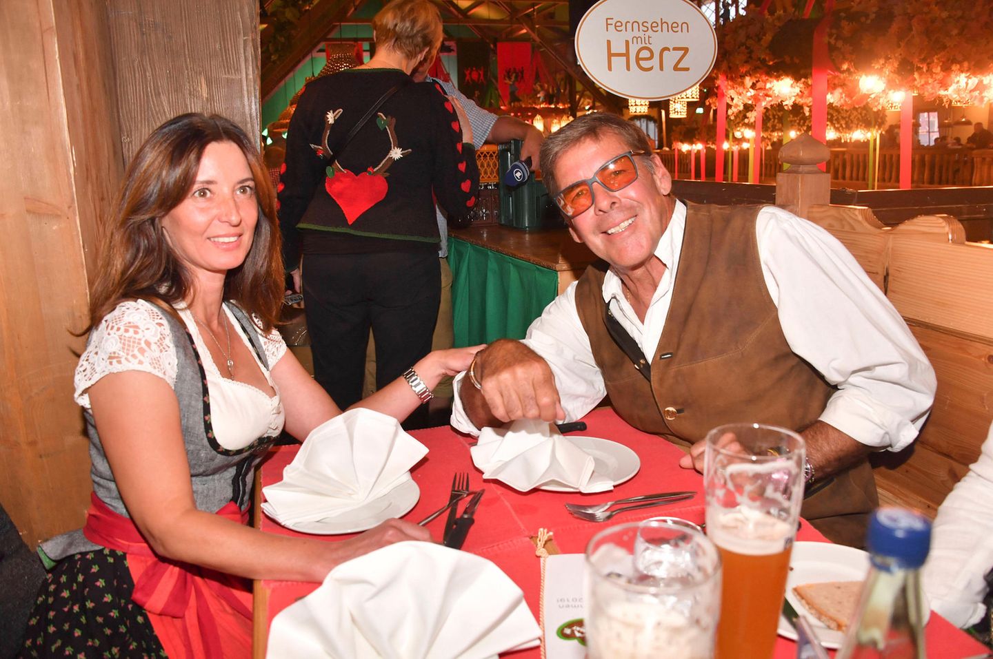 Sascha Hehn 2019 mit seiner Freundin Gloria beim Oktoberfest. Sie trägt Dirndl, er Lederhosen