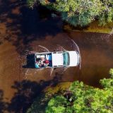 In einem Pick-up werden zwei Ehepaare, die evakuiert wurden, zurück in ihre Häuser gefahren