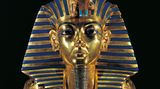 Goldene Mumien-Goldmaske des Tutanchamun vor schwarzem Hintergrund