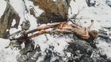 Mumie von Ötzi am Fundort auf dem Rücken liegend im Schnee zwischen Felsen