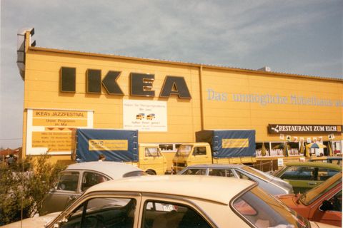 Die erste Ikea-Filiale in Deutschland, ein gelber Klotz bei München, vor dem 1974 VW-Käfer parken