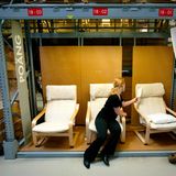 Eine Frau schaut sichg in einem Ikea-Möbelhaus den Sessel Poäng an