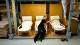 Eine Frau schaut sichg in einem Ikea-Möbelhaus den Sessel Poäng an