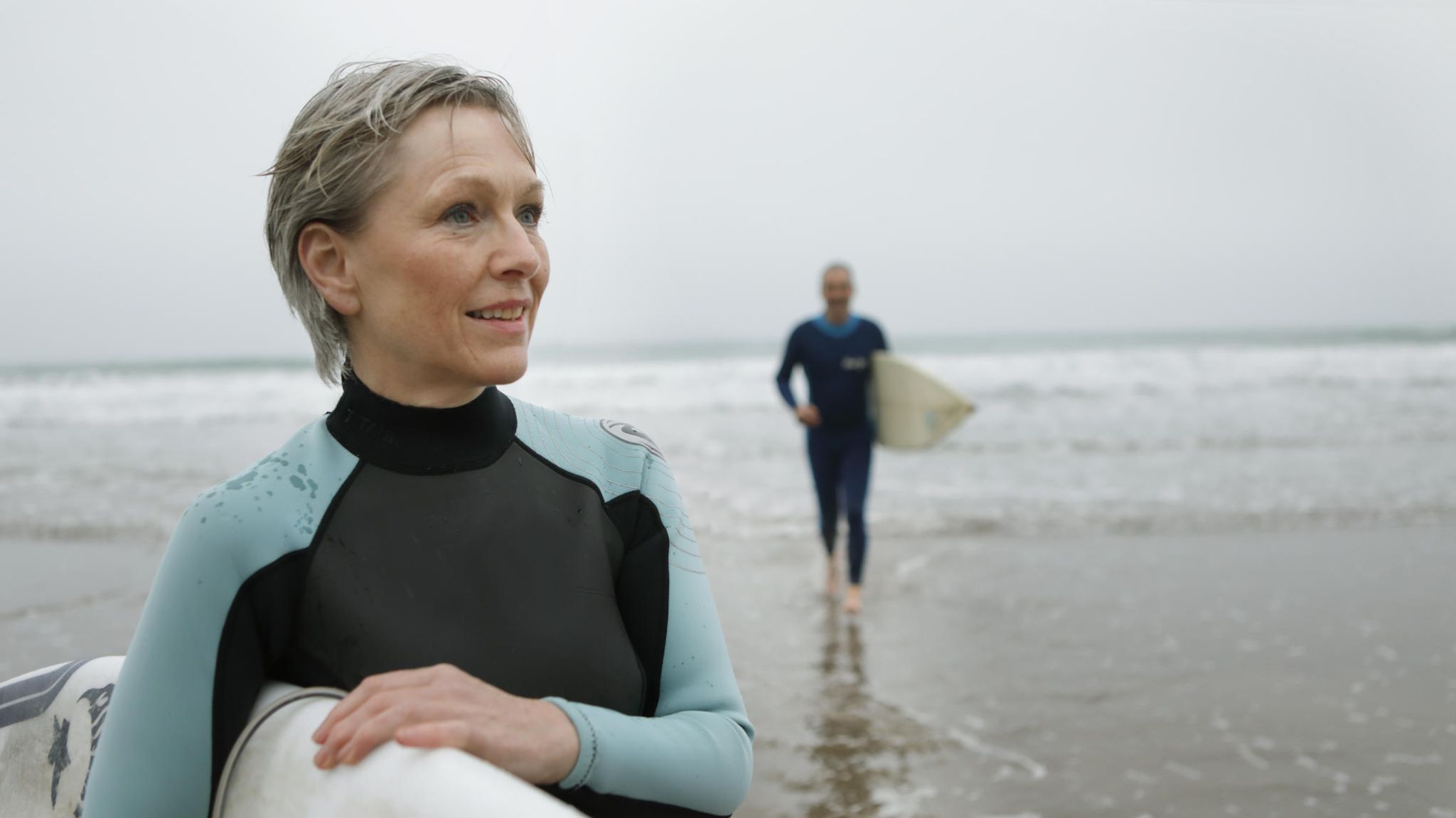 Frau mit Surfboard unterm Arm