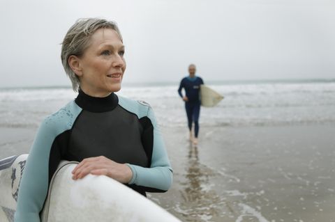 Frau mit Surfboard unterm Arm