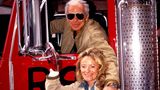 Ralph Lauren sitzt am Steuer eines roten Trucks, seine Frau Ricky steht davor