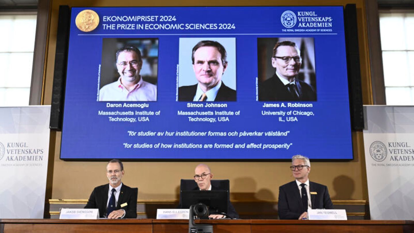 Wirtschaft: Forschung zu Wohlstand und Einkommensunterschieden durch Daron Acemoğlu, Simon Johnson und James A. Robinson Das Komitee der Akademie der Wissenschaften sitzt vor einer Präsentation und verkündet die Sieger.