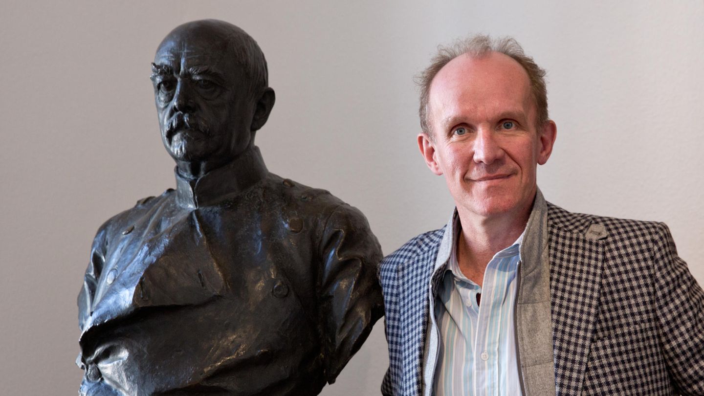 Der Adelige Gregor Graf von Bismarck neben einer Statue Otto von Bismarcks