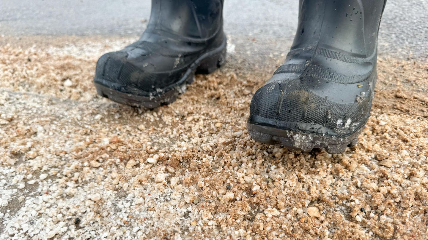 Mit Gummistiefeln auf einer Sandstraße mit Salz stehen
