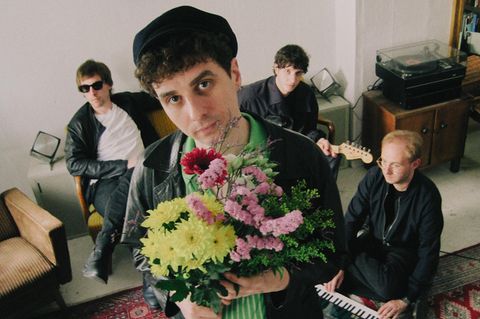 Die Band Isolation Berlin, der Frontmann hat einen Blumenstrauß in der Hand