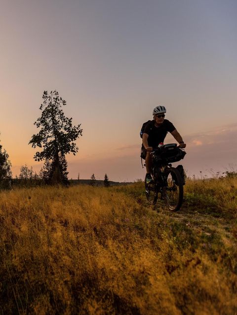 Reporter Stefan Schmitz fährt mit seinem Fahrrad im Sonnenuntergang in Thüringen