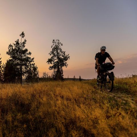 Reporter Stefan Schmitz fährt mit seinem Fahrrad im Sonnenuntergang in Thüringen