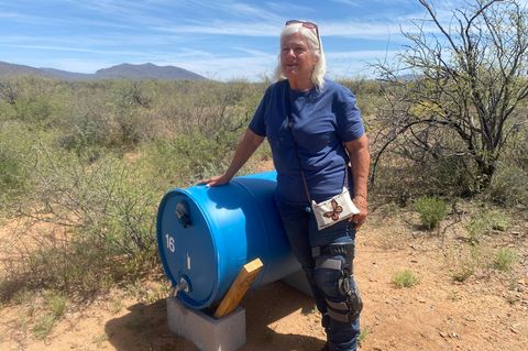 Gail Kocourek bei einem der Wasserfässer, die sie in der Wüste aufstellt, damit Migranten nicht verdursten. Donald Trumps Abschottungspolitik, der Joe Biden zum Teil gefolgt ist, führt zu dramatischen Verhältnissen an der Grenze zu Mexiko