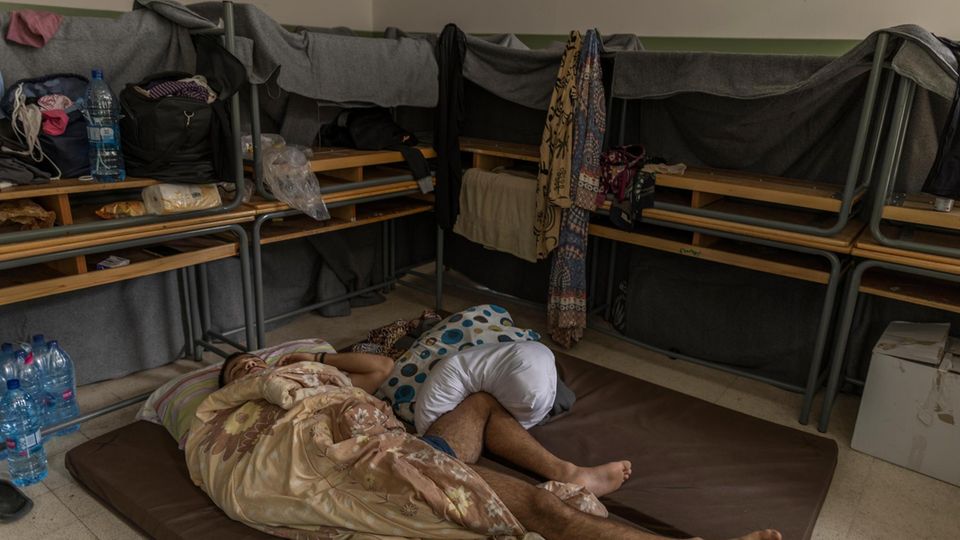 In einer zur Notunterkunft umfunktionierten Schule haben sich Geflüchtete aus Bänken und Decken einen kleinen Raum gebaut