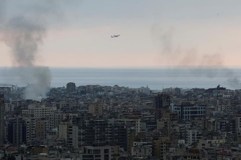 Eine Maschine der Middle East Airlines nach dem Start vom Rafiq-Hariri-Flughafen in Beirut – aus den Wohnvierteln am Rand des Airports steigt nach einem Bombardement noch Rauch auf