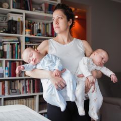 Mutter mit zwei Neugeborenen auf dem Arm
