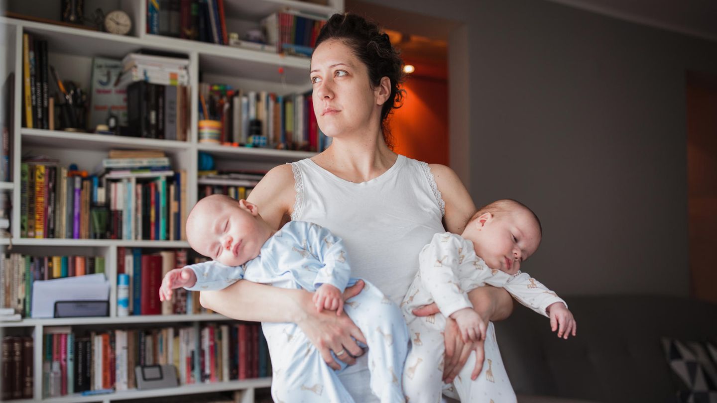 Mutter mit zwei Neugeborenen auf dem Arm Mutter mit zwei Neugeborenen auf dem Arm