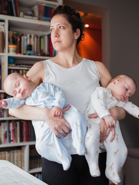 Mutter mit zwei Neugeborenen auf dem Arm