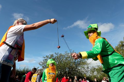 Bei der Conkers-WM 2017 in Southwick versucht ein verkleideter Mann die Kastanie einer Frau mit seiner zu zerschlagen
