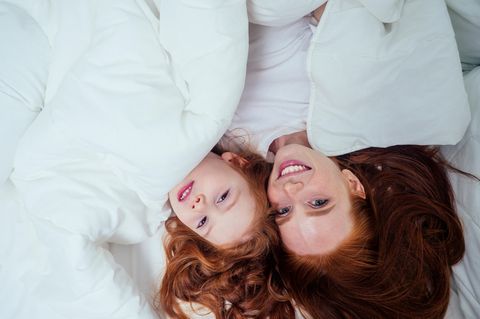Lidl Deals am Wochenende: Mutter und Tochter kuscheln sich in Daunendecke