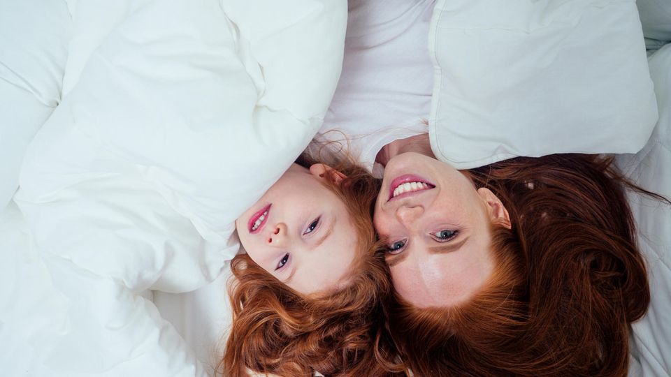 Lidl Deals am Wochenende: Mutter und Tochter kuscheln sich in Daunendecke