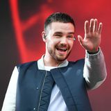 Sänger Liam Payne mit In Ear Kopfhörern und winkt.