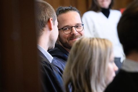Der Journalist Arne Semsrott mit seinen Verteidigern vor dem Landgericht Berlin