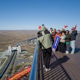 Eine Gruppe chinesischer Touristen posiert auf dem Aussichtsturm an der Grenze. Durch das große Tor auf chinesischer Seite verläuft eine Eisenbahnverbindung zwischen Russland und China. Derzeit passieren aber nur Güterwaggons