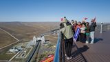 Eine Gruppe chinesischer Touristen posiert auf dem Aussichtsturm an der Grenze. Durch das große Tor auf chinesischer Seite verläuft eine Eisenbahnverbindung zwischen Russland und China. Derzeit passieren aber nur Güterwaggons