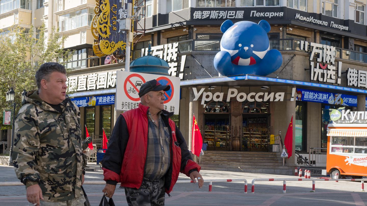 "Hurra, Russland!" heißt der Laden im Hintergrund, der russische Souvenirs anbietet. Die beiden Russen sind Lastwagenfahrer. Da die Wartezeit am Zoll derzeit eine Woche beträgt, vertreiben sie sich die Zeit in der Stadt 