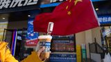 Im Kaffee To Go steckt eine kleine Wodka-Flasche: Eine junge Touristin aus dem chinesischen Chongqing hält die Mischung für ein russisches Getränk. "Hurra, Russland!" steht auf dem Becher 