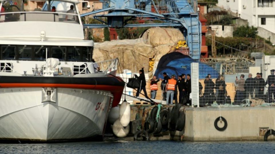 Migranten betreten Küstenwache-Schiff am Hafen von Shengjin