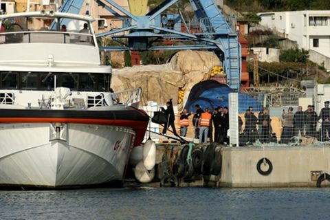 Migranten betreten Küstenwache-Schiff am Hafen von Shengjin