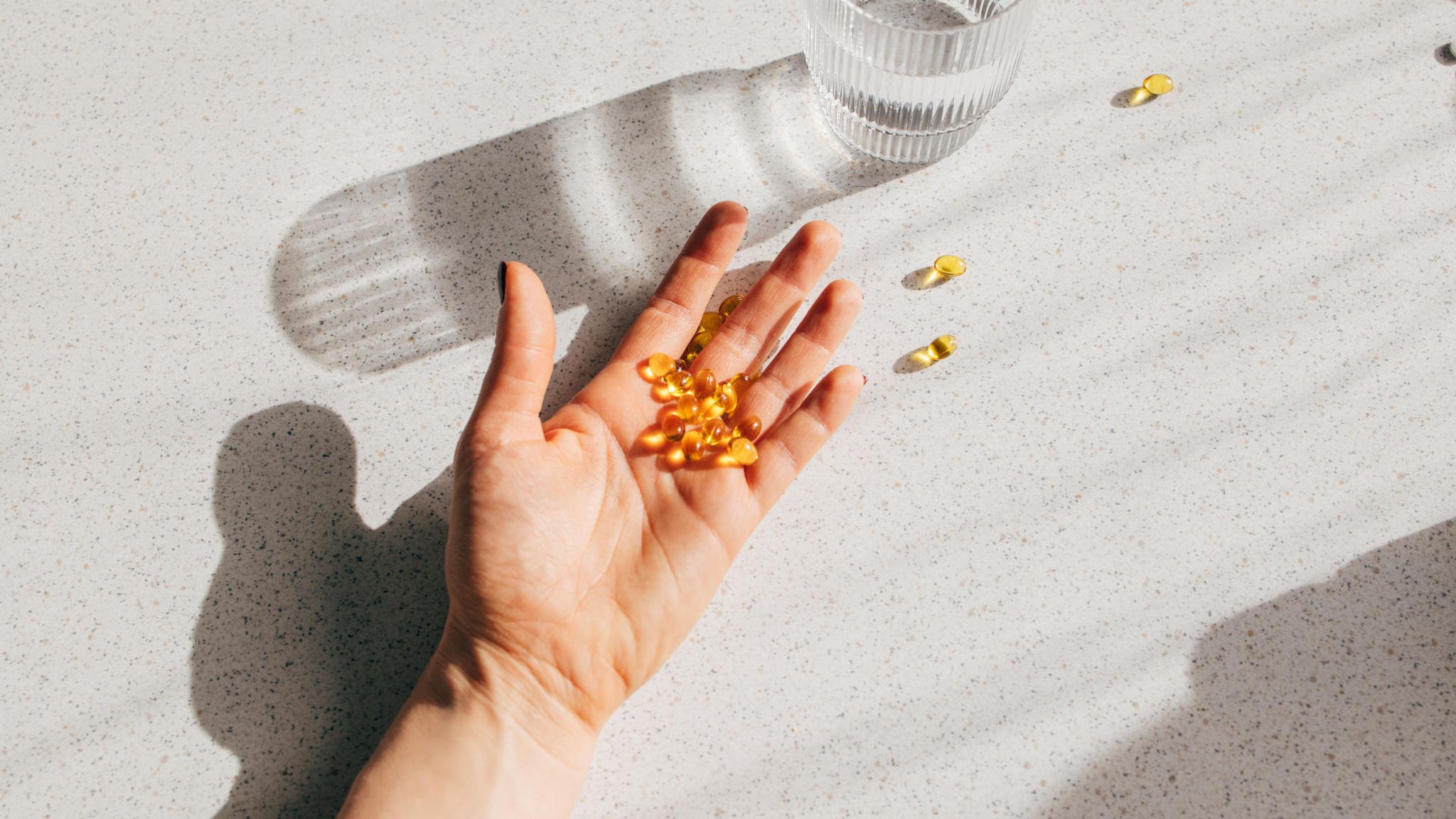 Eine Hand voller Vitamin D Tabletten liegt auf dem Tisch Eine Hand voller Vitamin D Tabletten liegt auf dem Tisch