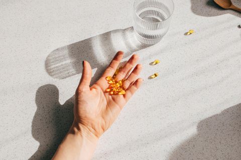 Eine Hand voller Vitamin D Tabletten liegt auf dem Tisch