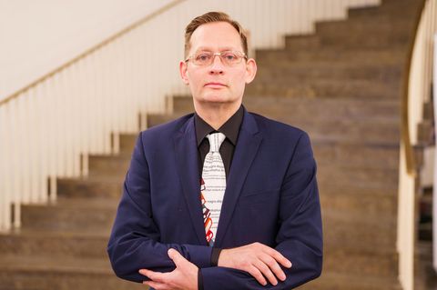Schriftsteller Clemens Meyer im blauen Jackett mit gemusterter Krawatte.