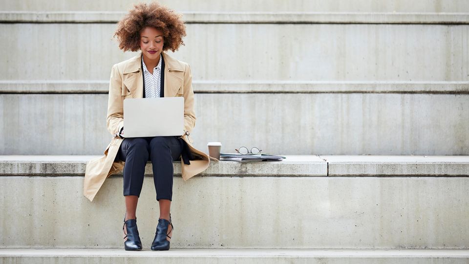 Frau mit HP-Notebook auf einer Treppe.