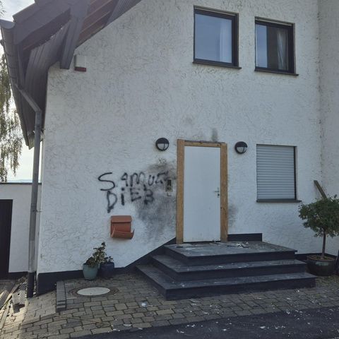 An der Eingangstür eines Hauses in Wachtberg sind Spuren einer Explosion zu sehen sowie der Schriftzug "Samuel Dieb"