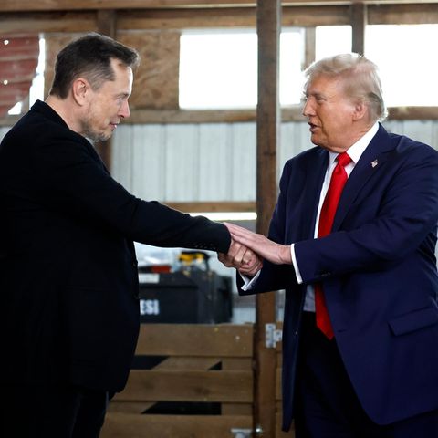 Elon Musk schüttelt hinter der Bühne während einer Wahlkampfveranstaltung auf der Butler Farm Show Donald Trump die Hand