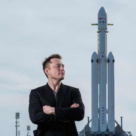 Elon Musk posiert mit der SpaceX Falcon Heavy-Rakete