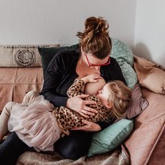 Langzeitstillen: Eine Frau stillt ihr fast vierjähriges Kind auf dem Sofa