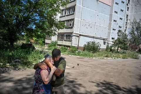 Ein Mann hält eine Frau in der Ukraine im Arm