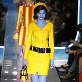 Auf der Mailänder Modewoche 2018 präsentierte Moschino eine Herbst-Winter-Kollektion, die uns direkt in die schillernden 60er-Jahre zurückbeamte. Die Models trugen pastellfarbene Kleider mit eleganten Pillbox-Hüten à la Jackie Kennedy und hatten ihre Haut blau, grün und orange eingefärbt. Eine Anspielung auf Verschwörungstheorien, die besagen, dass die First Lady eine Alien-Undercover-Agentin war