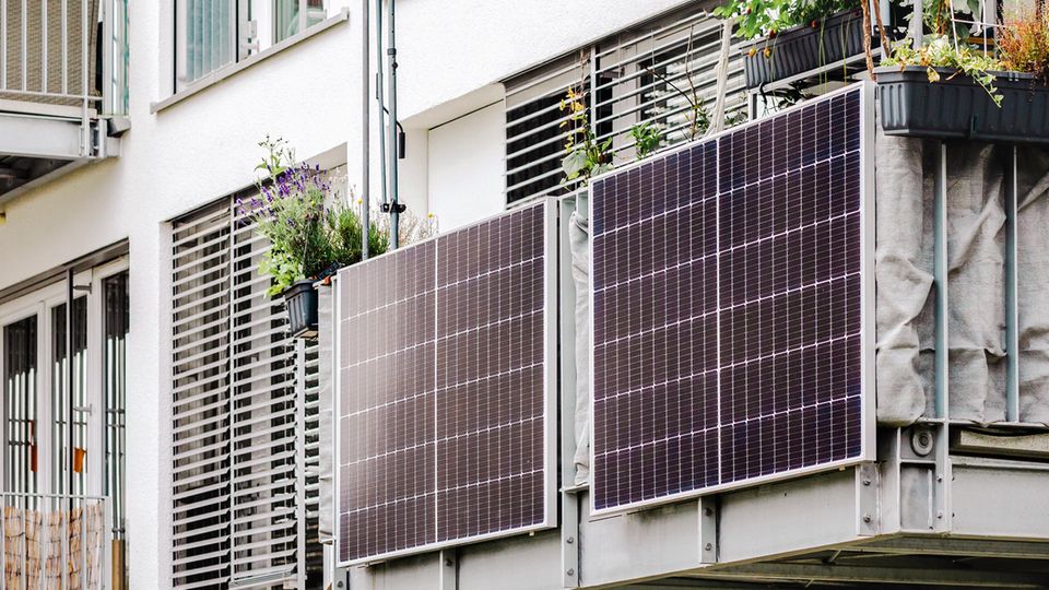 Balkonkraftwerk-Speicher kaufen: Zwei Solarmodule am Balkongeländer eines Mehrfamilienhauses.